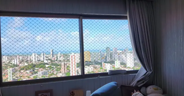 Janela de apartamento com tela de proteção e vista para Recife